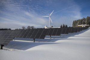 Painéis solares com aerogerador ao fundo